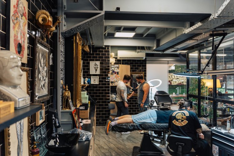 A photo of a tattoo studio with a large Doctor Pepper logo on the wall.