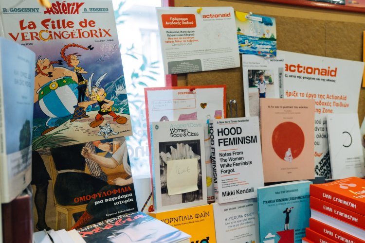 A bulletin board displaying books, flyers, and notes, including a comic book cover and a feminist title.