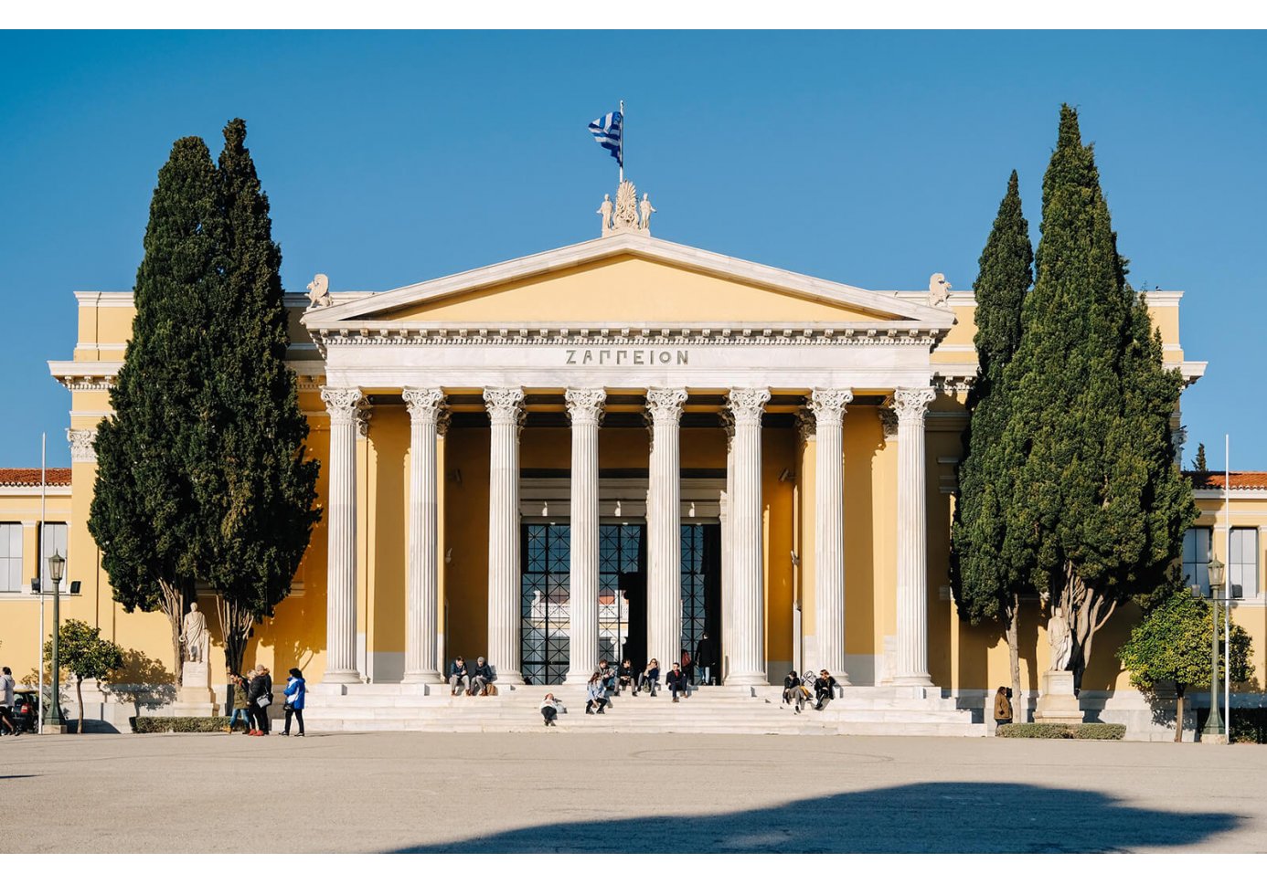 people in front of a neoclassical building in athens