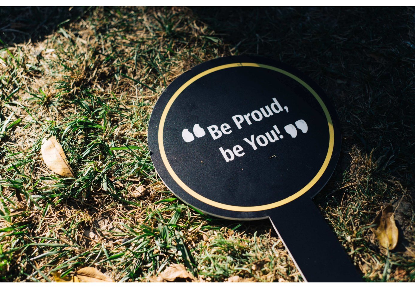 a back round sign that says Be Proud, Be You