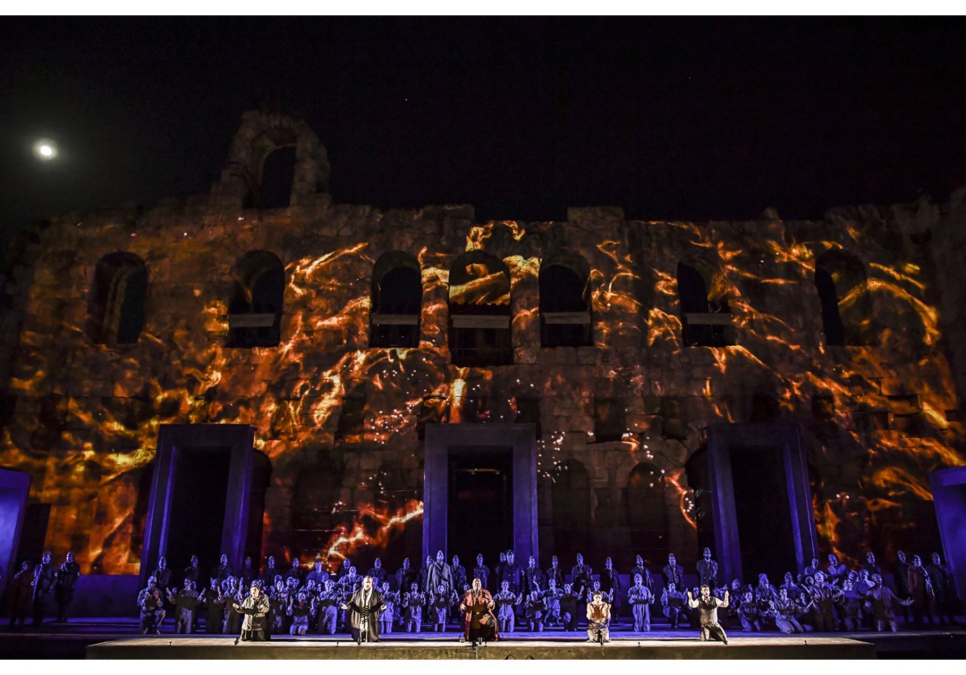 actors perfmorning on stage in an ancient theatre, night time.