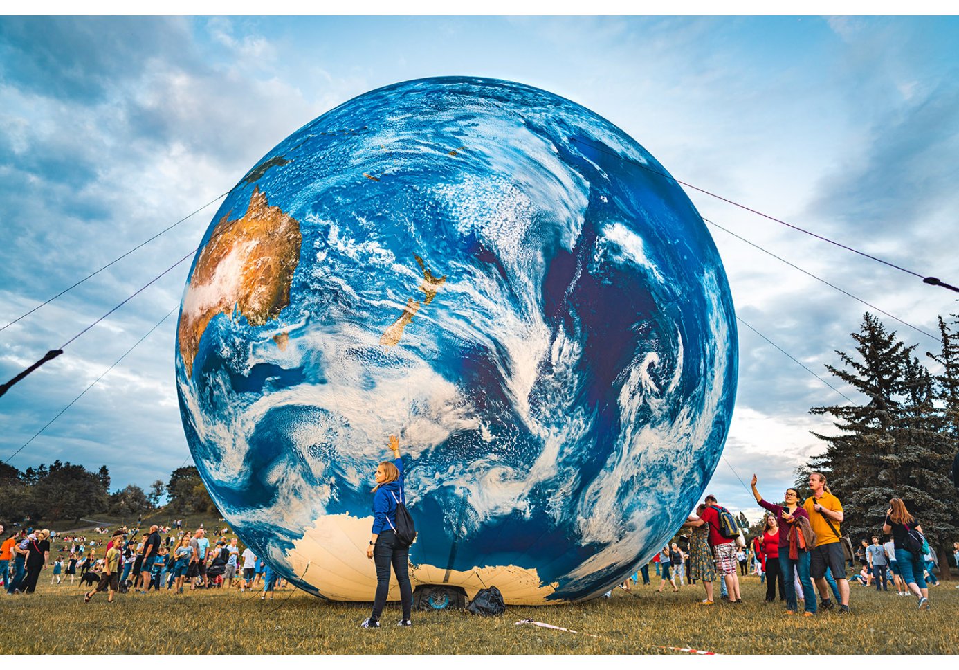 inflatable model of the Earth at a park, people around