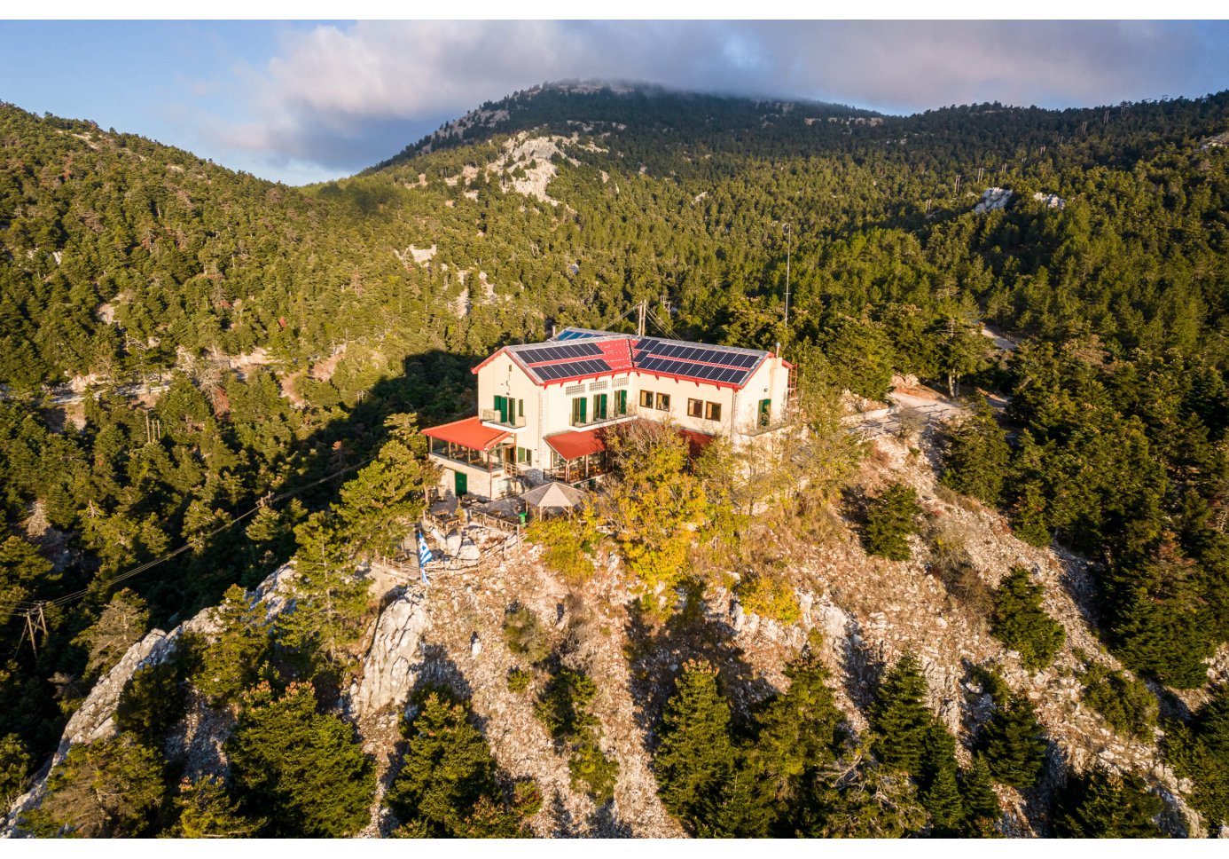 An aerial view of a mountaintop refuge with a large, two-story building. 