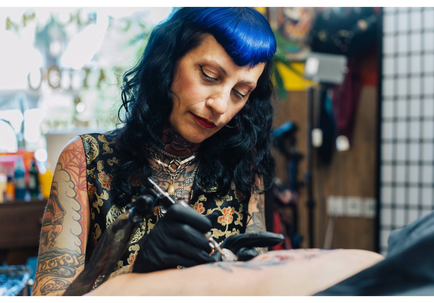 a woman tattooing someone