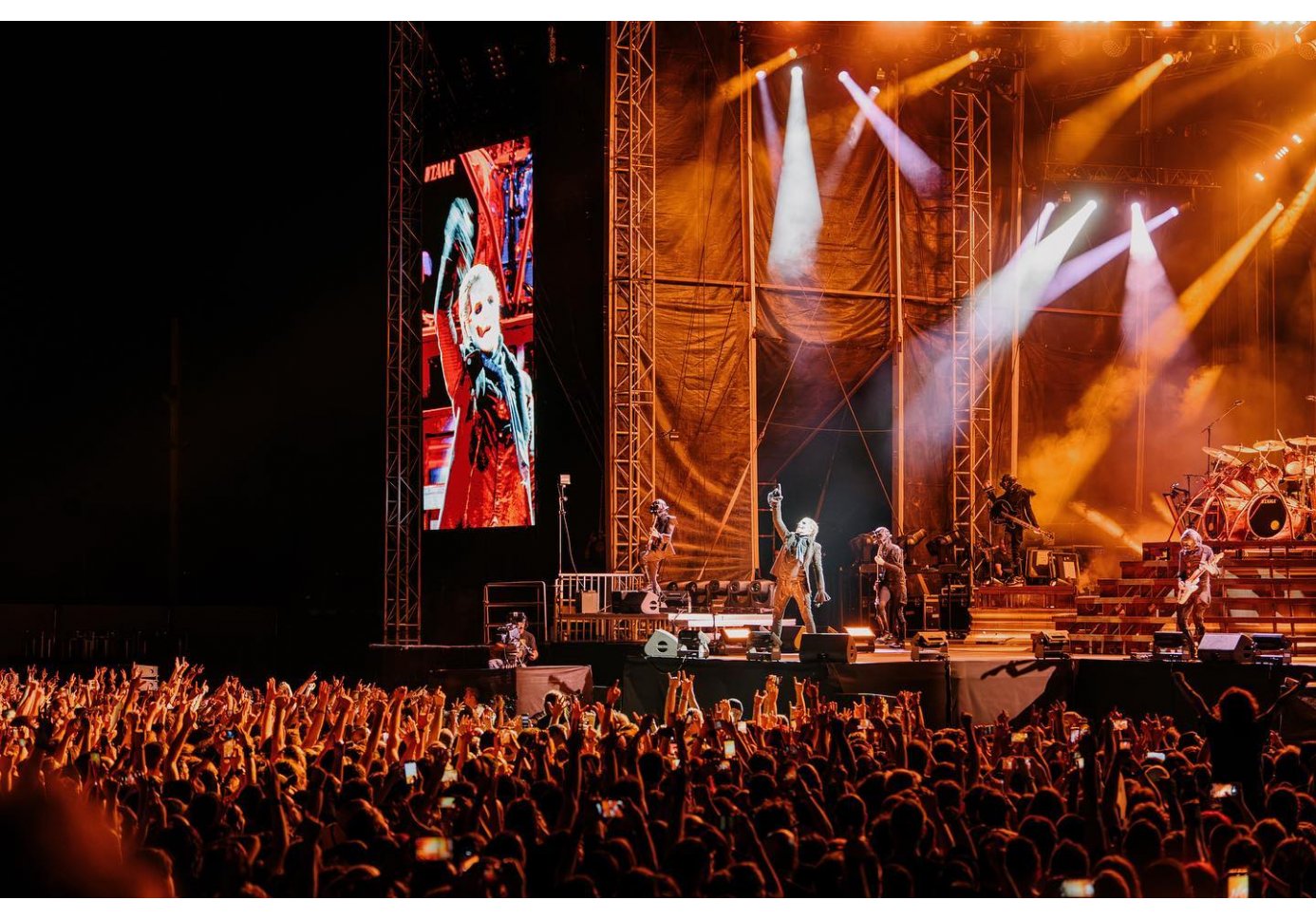 a band performing on stage, crowd cheering